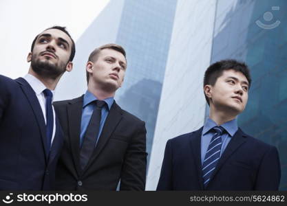 Portrait of three serious businessmen, outdoors, business district