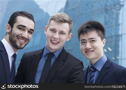 Portrait of three smiling businessmen, outdoors, business district
