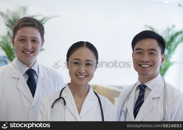 Portrait of three smiling doctors in the hospital, multi-ethnic group