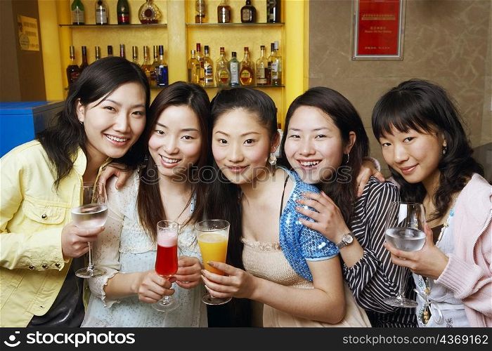 Portrait of three teenage girls and two young women holding drinks