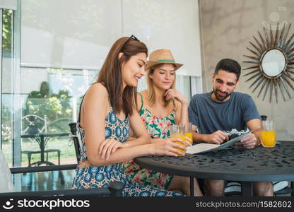 Portrait of three travelers friends spending some time and organizing their trip at the hotel. Travel and lifestyle concept.