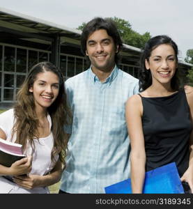 Portrait of three university students standing together and smiling