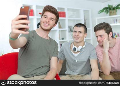 portrait of three university students taking a selfie at home