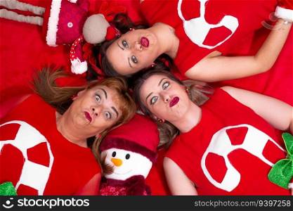 Portrait of three women making funny faces from above in christmas mood