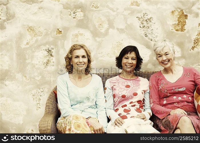 Portrait of three women sitting on a couch and smiling