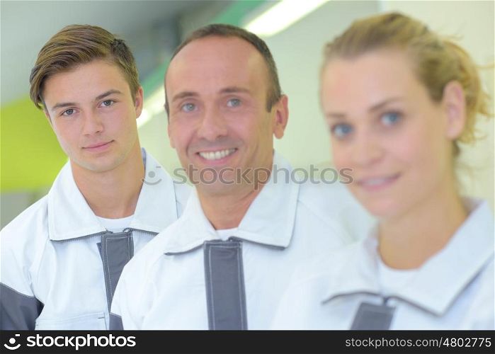 Portrait of three workers in matching coveralls