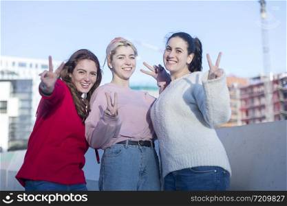 Portrait of three young happy girls sitting together and gesturing