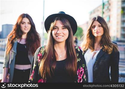 Portrait of three young women in city