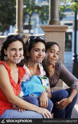 Portrait of three young women sitting and smiling, Old San Juan, San Juan, Puerto Rico