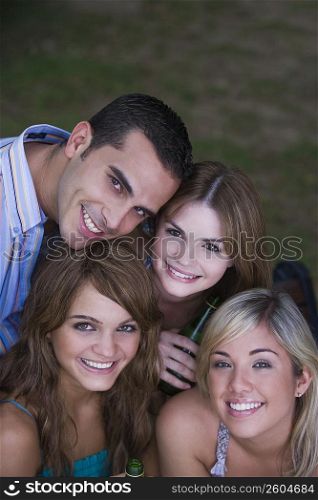Portrait of three young women smiling with a young man
