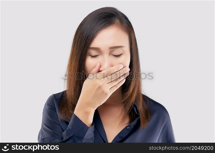 Portrait of tired girl who yawns. A woman yawning on a light gray background