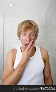 Portrait of tired man yawning in bathroom