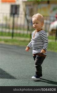 Portrait of toddler child outdoors. One year old baby boy at playground