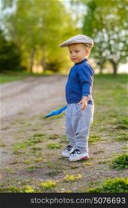 Portrait of toddler child outdoors. Rural scene with one year old baby boy wearing flat cap