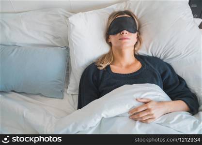 Portrait of traveler woman relaxing and peacefully sleeping with sleep mask at hotel room. Travel concept.