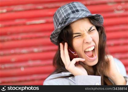 Portrait of trendy girl shouting on the phone