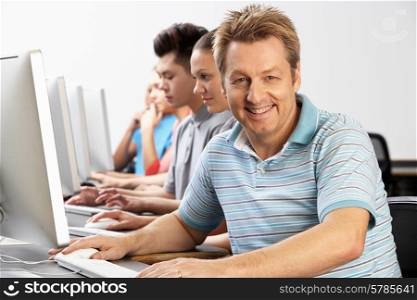 Portrait Of Tutor With Students In Computer Class