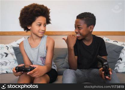Portrait of two Afro American brothers playing video games at home. Lifestyle and technology concept.