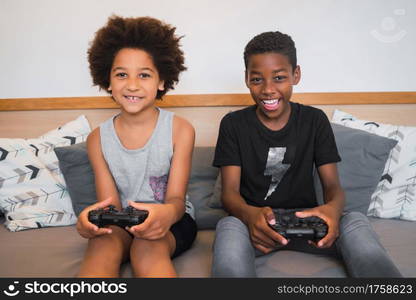 Portrait of two Afro American brothers playing video games at home. Lifestyle and technology concept.