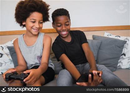 Portrait of two Afro American brothers taking a selfie with mobile phone at home. Lifestyle and technology concept.