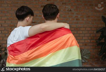 Portrait of two asian men with rainbow flag showing LBGT concept.