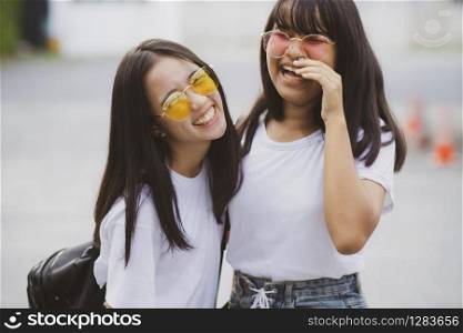 portrait of two asian teenager relaxing with happiness in green park