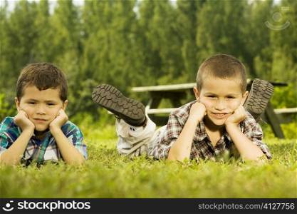 Portrait of two boys lying on the lawn