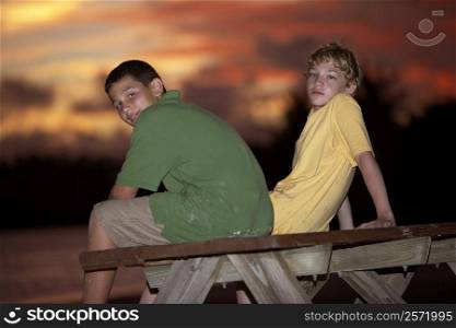 Portrait of two boys sitting on a picnic table