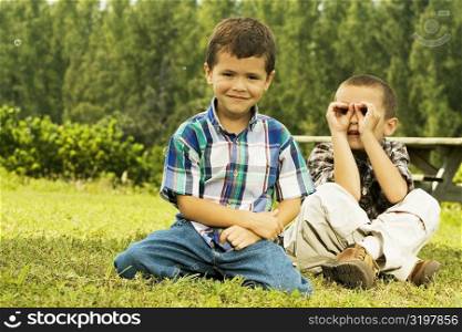 Portrait of two boys sitting on the lawn