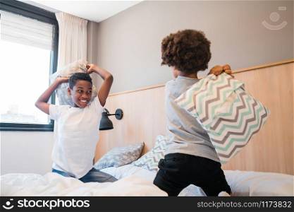 Portrait of two brothers fighting and playing with pillows at home. Lifestyle concept.