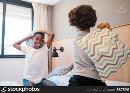Portrait of two brothers fighting and playing with pillows at home. Lifestyle concept.