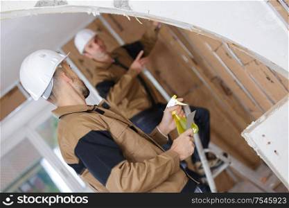 portrait of two builder working indoor