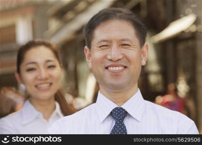 Portrait of two Business People, focus on businessman, outdoors, Beijing
