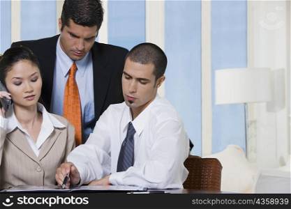 Portrait of two businessmen and a businesswoman in an office
