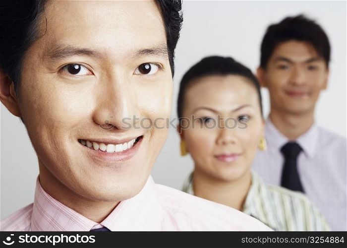Portrait of two businessmen and a businesswoman smiling