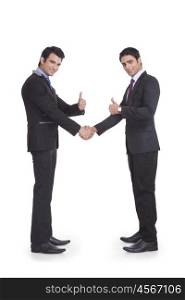 Portrait of two businessmen giving thumbs up