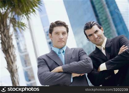 Portrait of two businessmen standing with their arms crossed