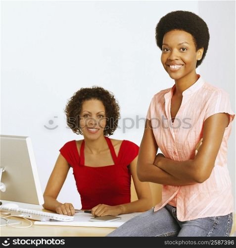 Portrait of two businesswomen sitting in an office and smiling