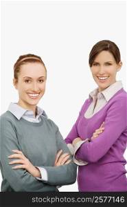 Portrait of two businesswomen standing with their arms crossed and smiling
