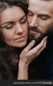 portrait of two caucasian lovers. Young couple is hugging on autumn day outdoors. A bearded man and curly woman in love. Valentine’s Day. Concept of love and family. portrait of two caucasian lovers. Young couple is hugging on autumn day outdoors. A bearded man and curly woman in love. Valentine’s Day. Concept of love and family.