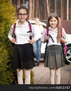 Portrait of two cheerful girls going to school at morning