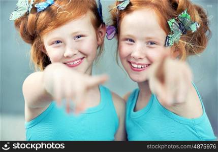 Portrait of two cheerful redhead twin sisters