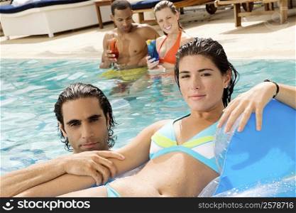 Portrait of two couples in a swimming pool
