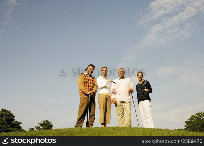 Portrait of two couples standing on a golf course