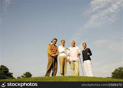 Portrait of two couples standing on a golf course