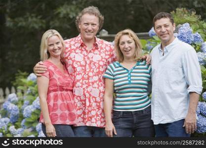 Portrait of two couples standing together and smiling in a park