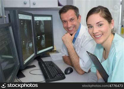 portrait of two doctors smiling in monitoring room in hospital