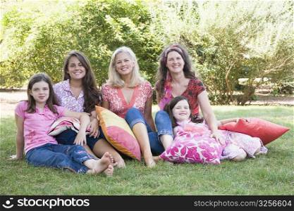 Portrait of two families sitting on grass