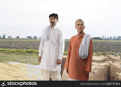 Portrait of two farmers standing in field