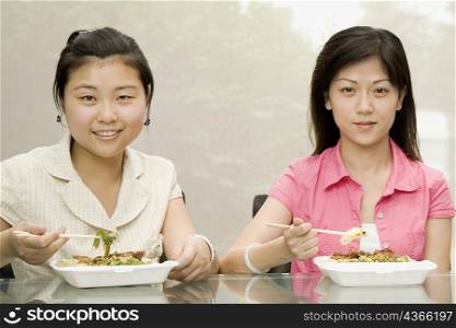 Portrait of two female office workers having lunch